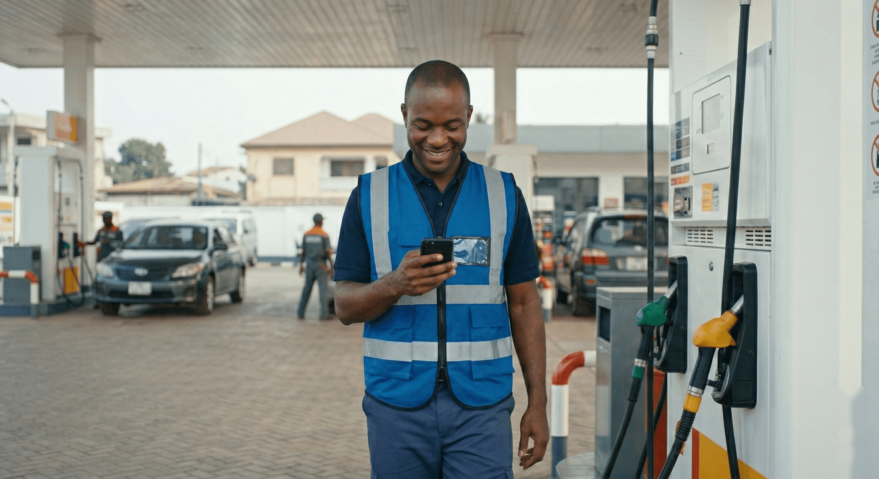 Pompiste utilisant une application mobile à une pompe à carburant